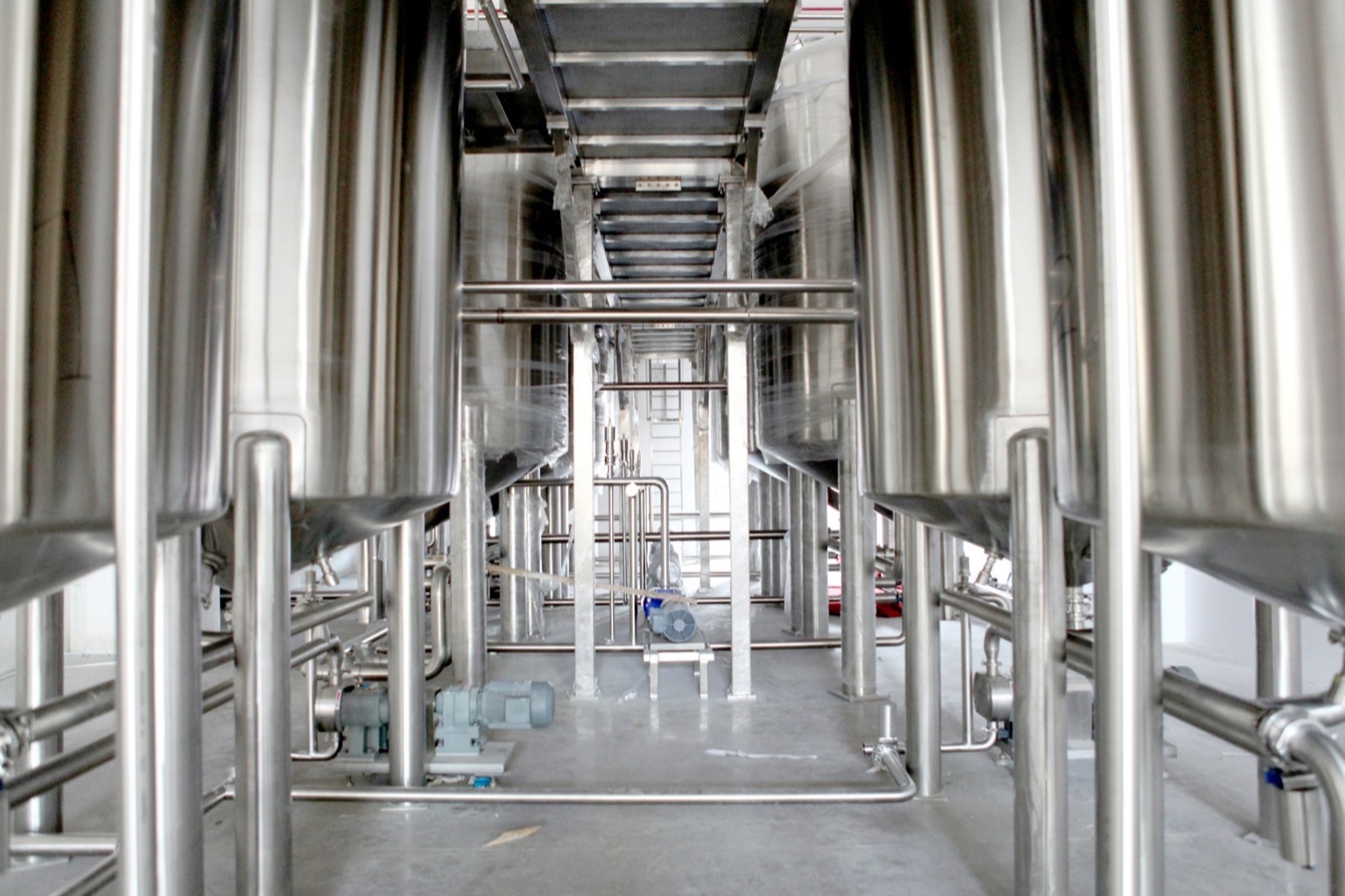 Rows of stainless steel vessels in a bright industrial hall